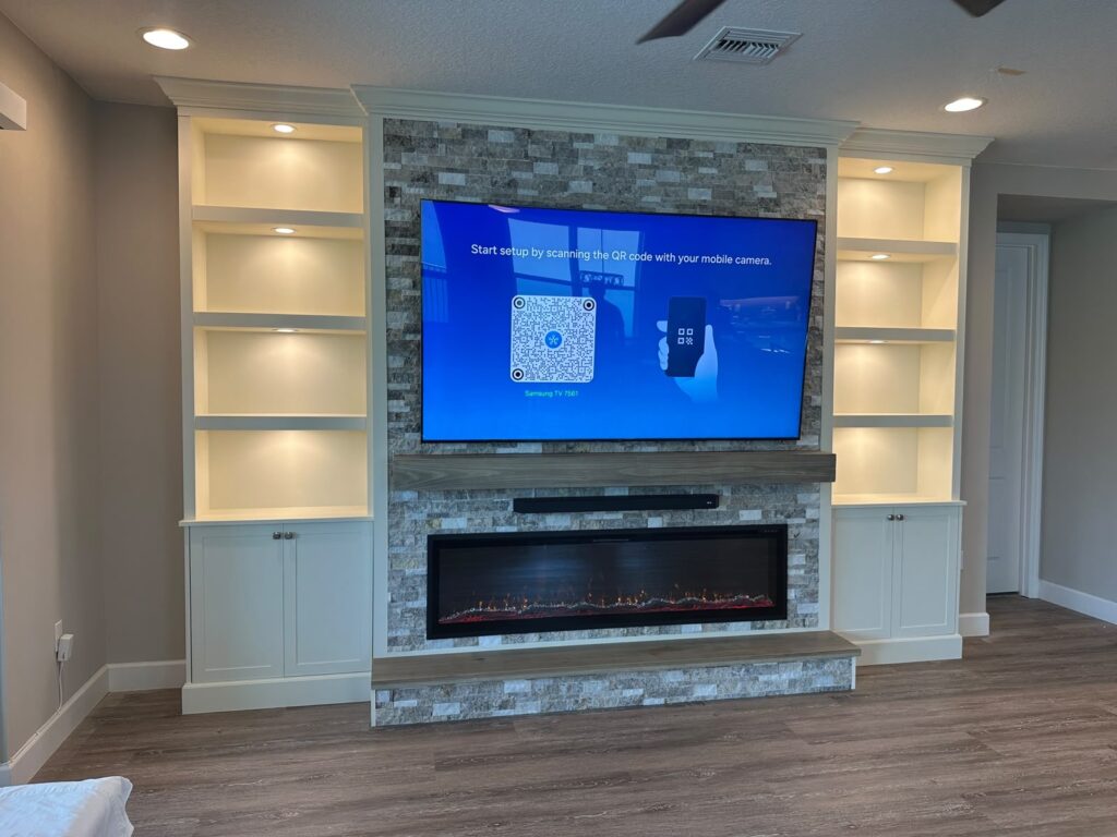 Stone Fireplace Media Wall with Built-In Cabinets and Shelving | Lux Nook Design Custom stone fireplace media wall with built-in shelving, LED lighting, floating mantel, electric fireplace, and entertainment center cabinetry.
