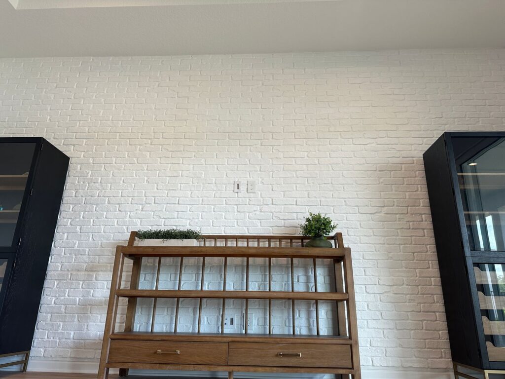 White brick accent wall with built-in wood cabinet