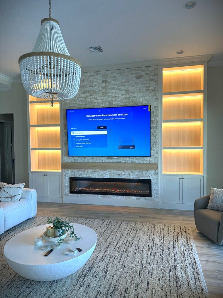 Luxury Ledgerstone Fireplace Media Wall Project Luxury white fireplace media wall with illuminated display shelves, custom cabinetry, and a linear electric fireplace