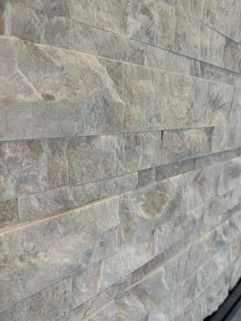 Close-up of stone finish on custom stone fireplace TV wall