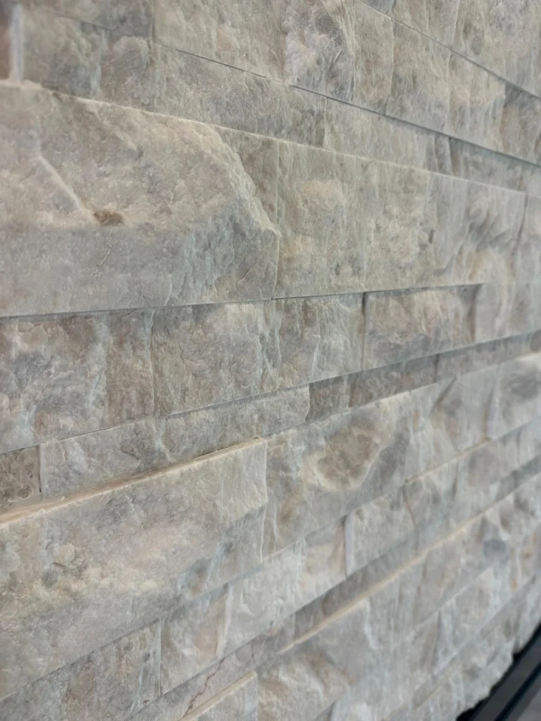 Close-up of stone finish on custom stone fireplace TV wall