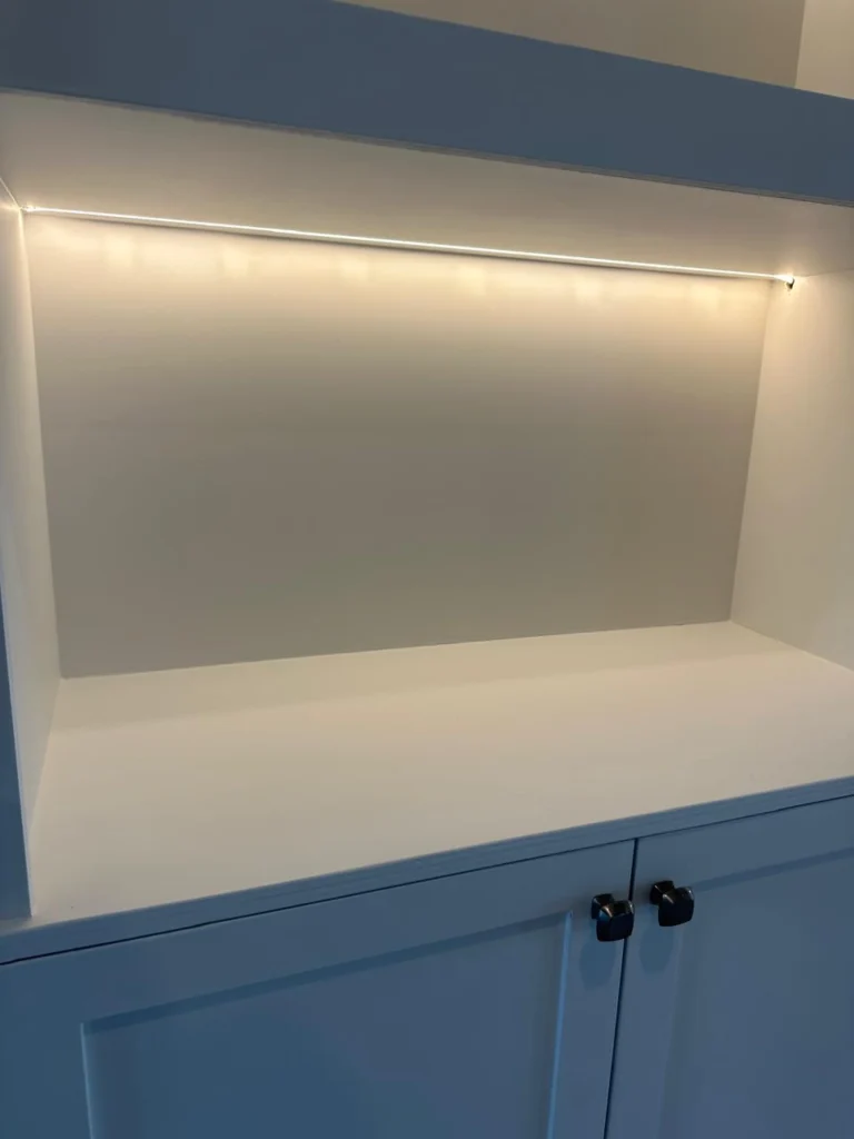 LED illuminated shelf detail on custom stone fireplace TV wall