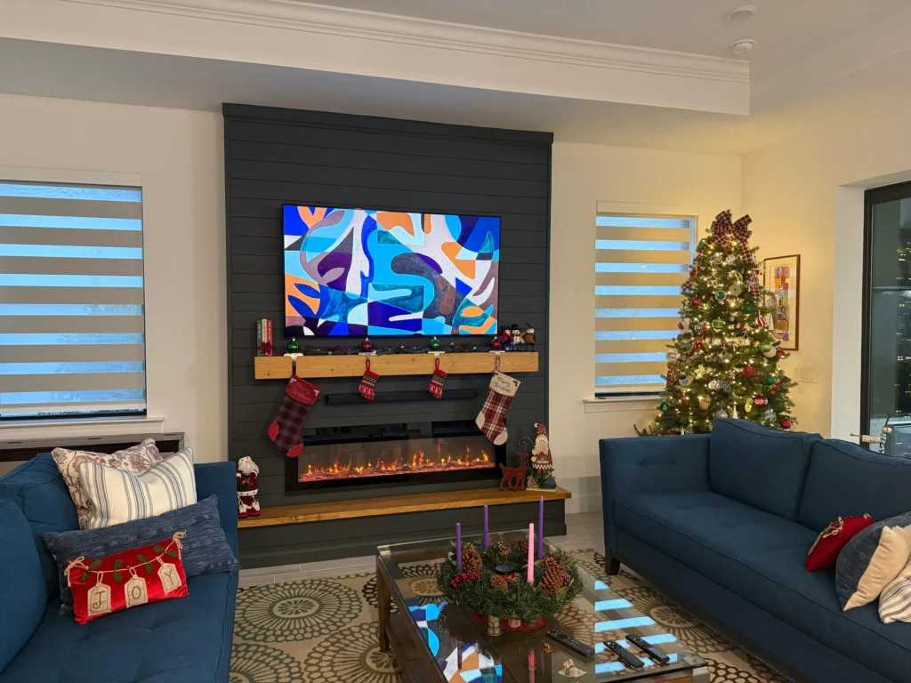Completed dark shiplap fireplace wall with TV, electric fireplace, floating wood mantel, and matching bench