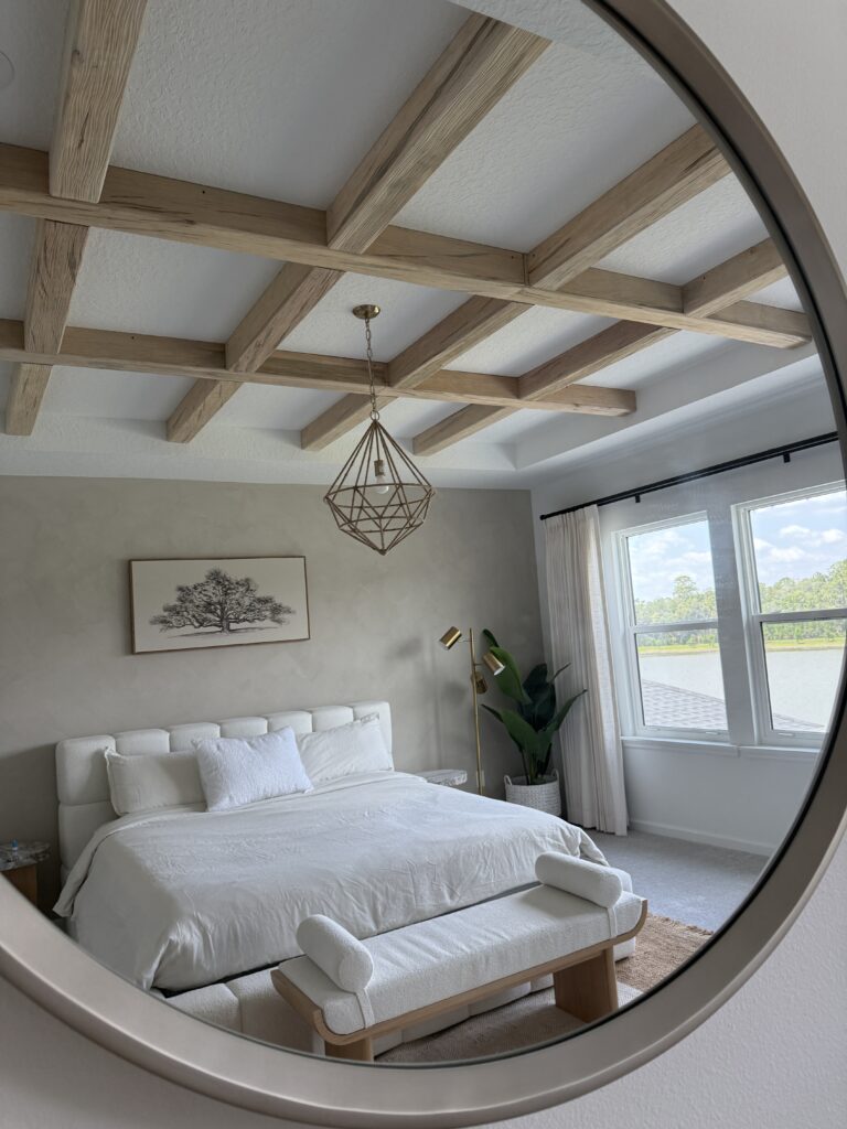 Modern wood beam ceiling with natural wood beams reflected in round mirror in luxury bedroom