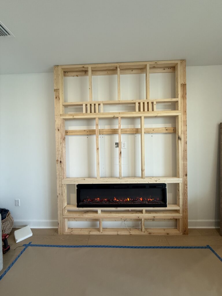 Framing process for classic stone fireplace wall with electric fireplace opening and built-in cabinet layout