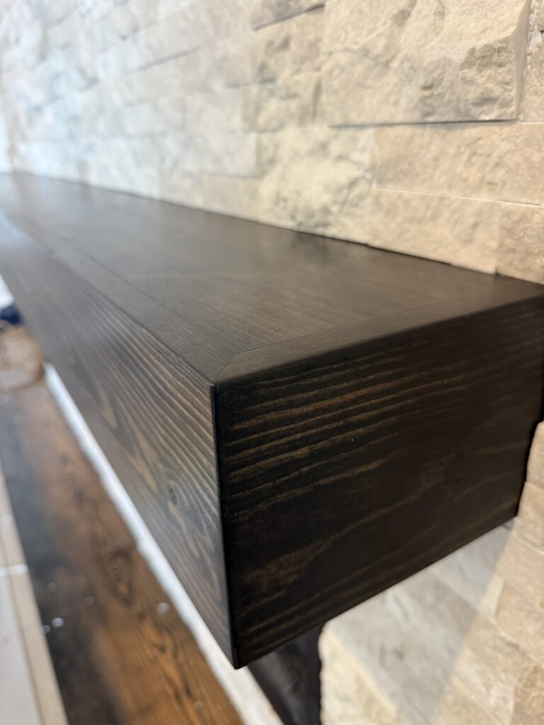 Floating wood bench detail on custom stone fireplace media wall with textured ledger stone finish