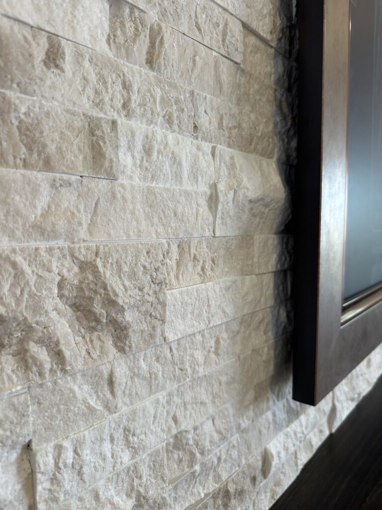 Close-up of recessed TV detail on stone fireplace media wall with natural ledger stone texture