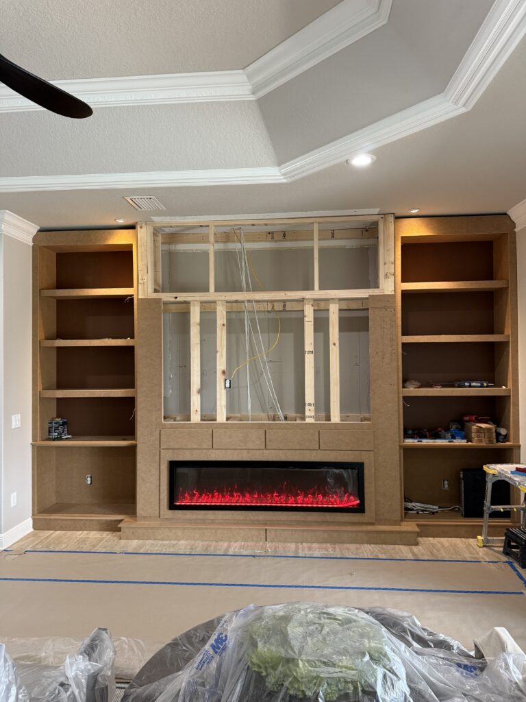 Framing process for custom dark built in media wall with fireplace opening