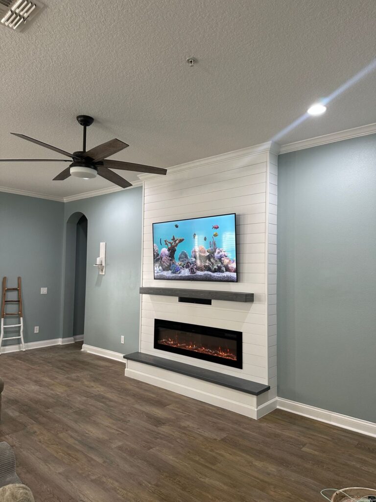 Floor-to-ceiling white shiplap fireplace wall with floating bench and linear electric fireplace
