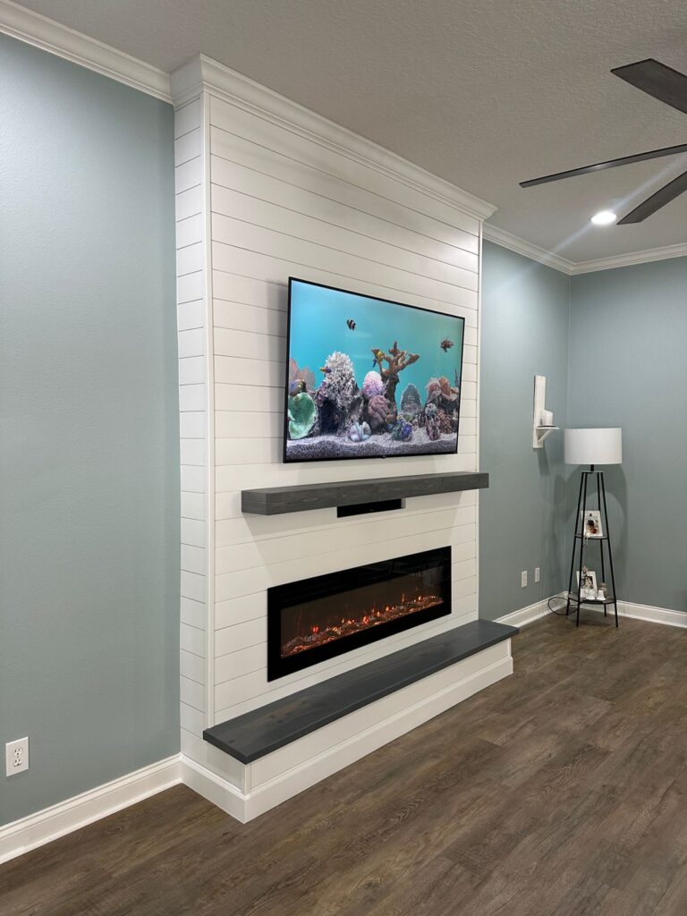 Modern white fireplace wall with handcrafted floating mantel, soundbar integration, and electric fireplace