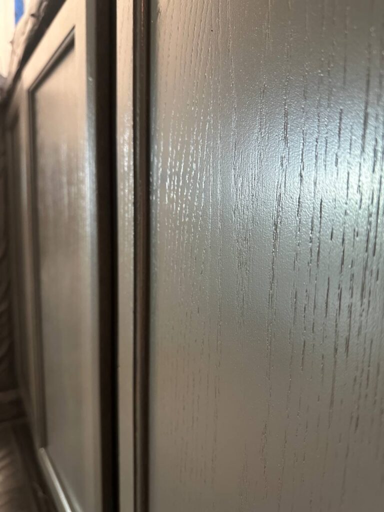 Close-up of black lower cabinet finish on fireplace TV wall with cabinets