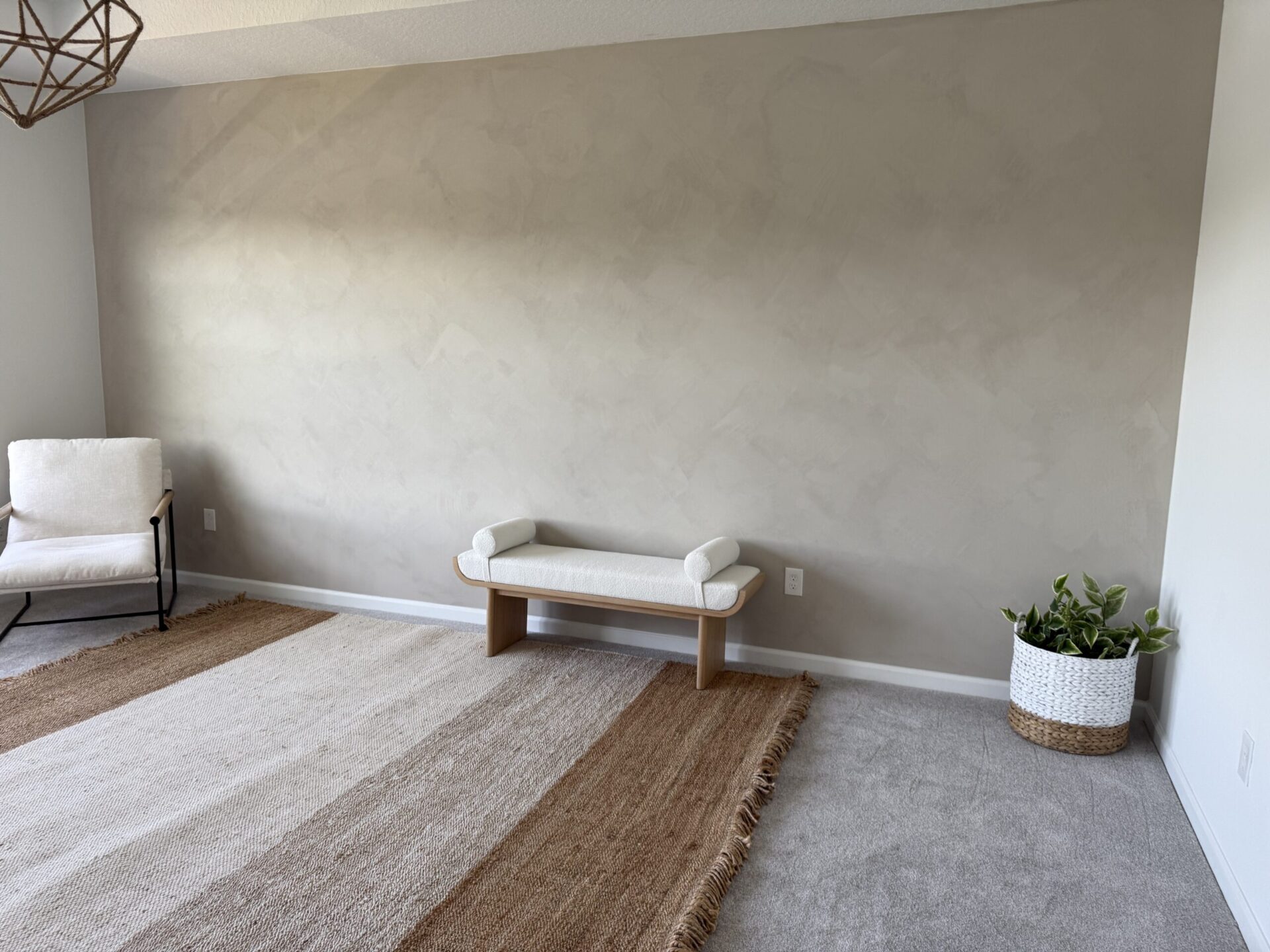Finished minimal limewash accent wall with soft mineral texture and neutral bedroom styling