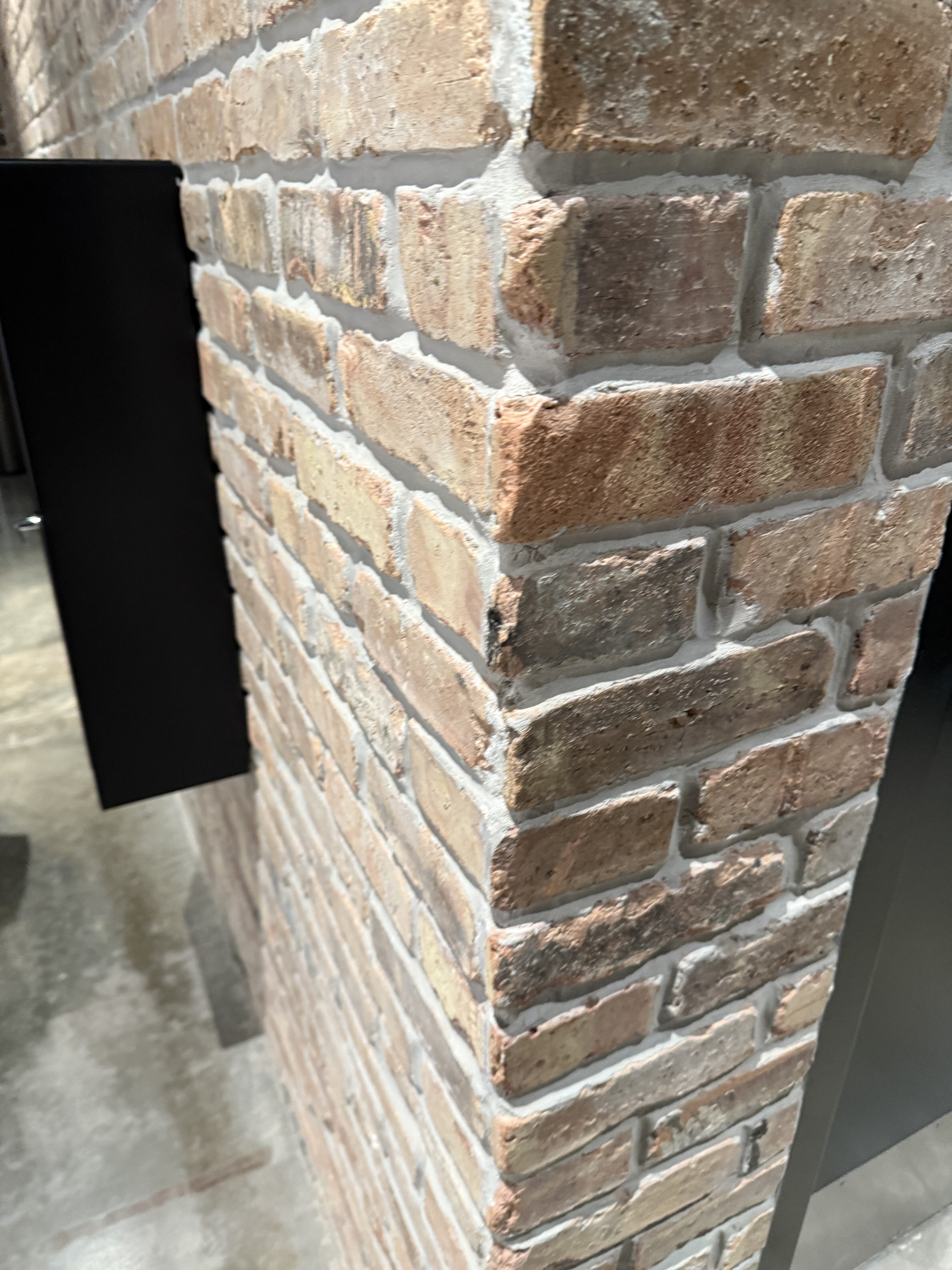 Close-up of rustic brick accent wall corner with aged brick texture and natural color variation