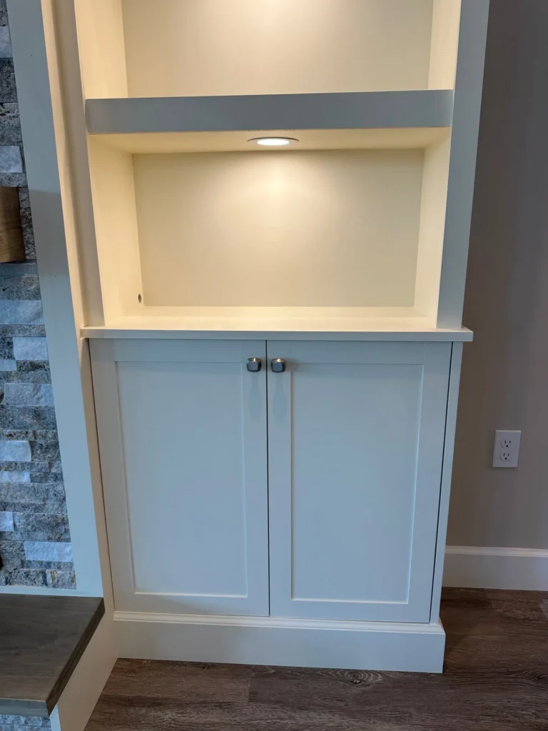 Built-in shelf and lower cabinet detail on stone fireplace media wall with LED lighting