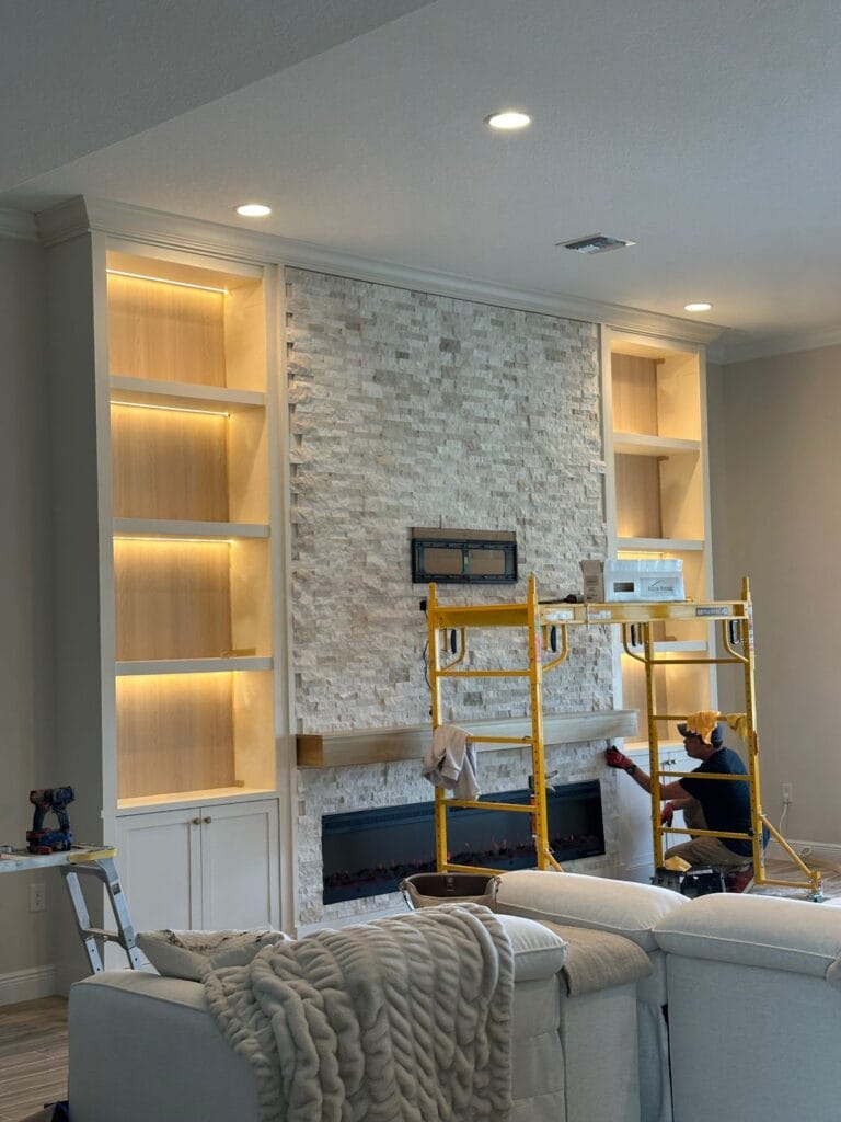 Finished stone TV media wall with built-in cabinets and linear fireplace