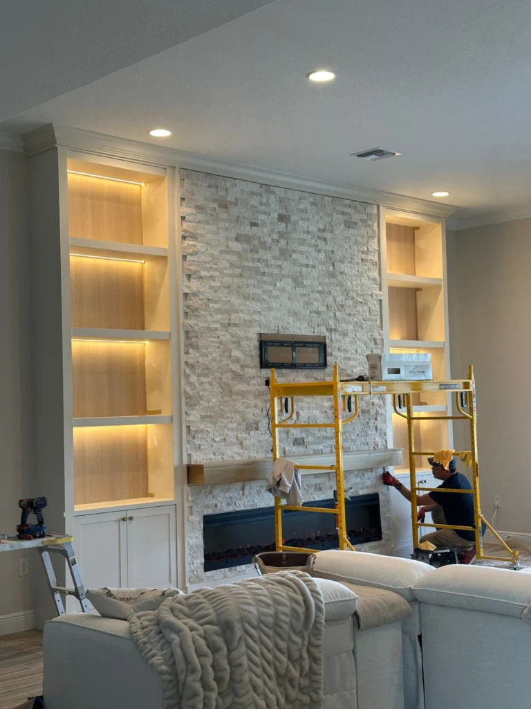 Finished stone TV media wall with built-in cabinets and linear fireplace