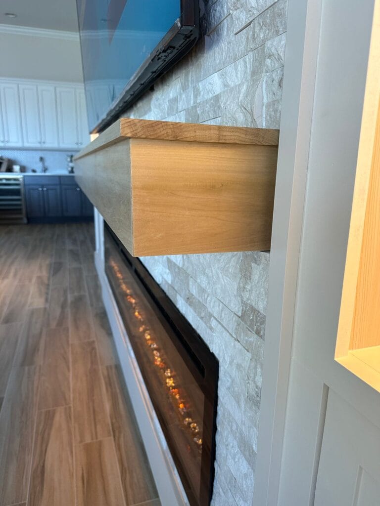 Linear electric fireplace built into custom stone TV media wall