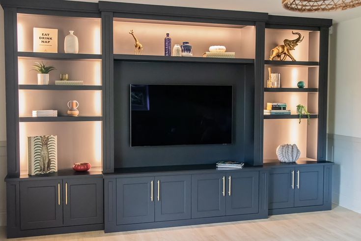 Recessed TV Area with Hidden Wiring Built-in entertainment wall in Tampa with recessed TV area, hidden wiring, dark cabinetry, open shelves, and integrated lighting