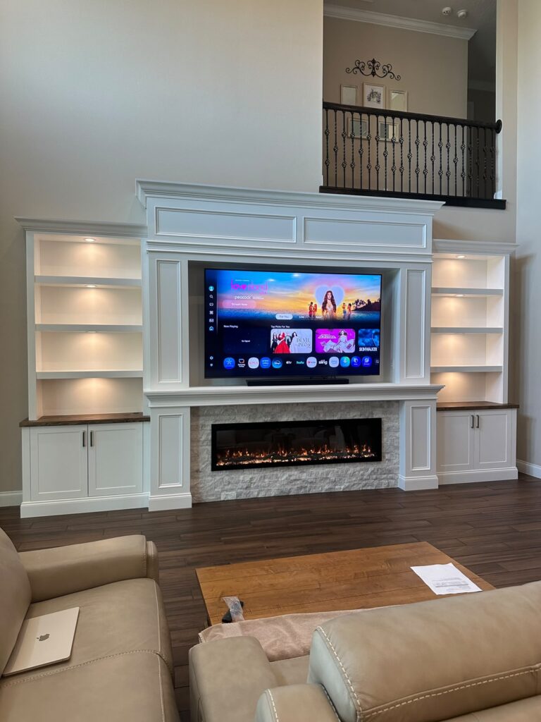 Luxury built-in media wall Luxury built-in media wall with fireplace, recessed TV, illuminated shelves, and custom cabinets