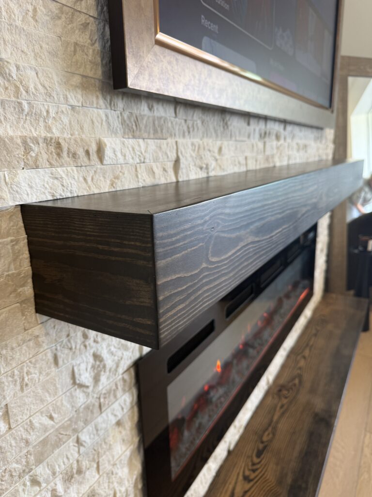 Stone Fireplace Wall with Wood Mantel Orlando Stone fireplace wall in Orlando with stained wood mantel, electric fireplace, and TV media wall detail
