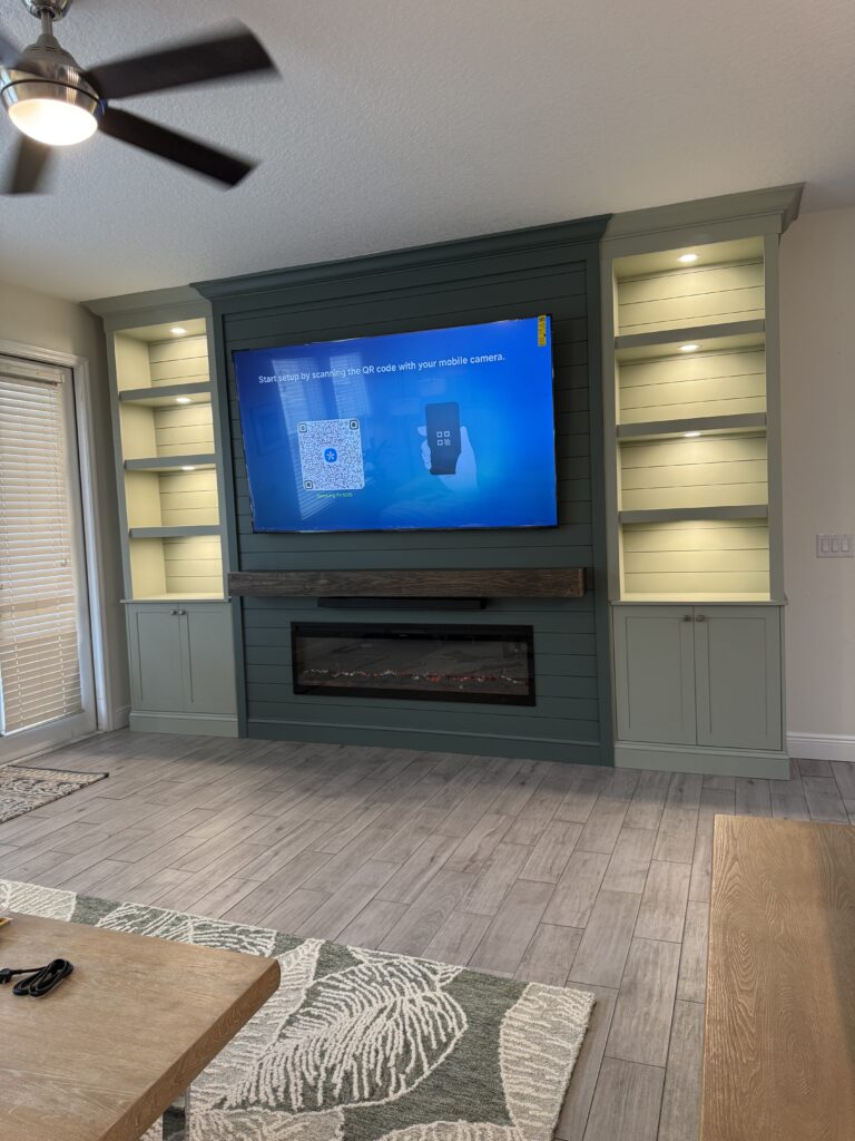 Finished TV Media Wall in Windermere Orlando Area Finished TV media wall in Windermere with electric fireplace, built-in cabinets, side shelving, and integrated lighting