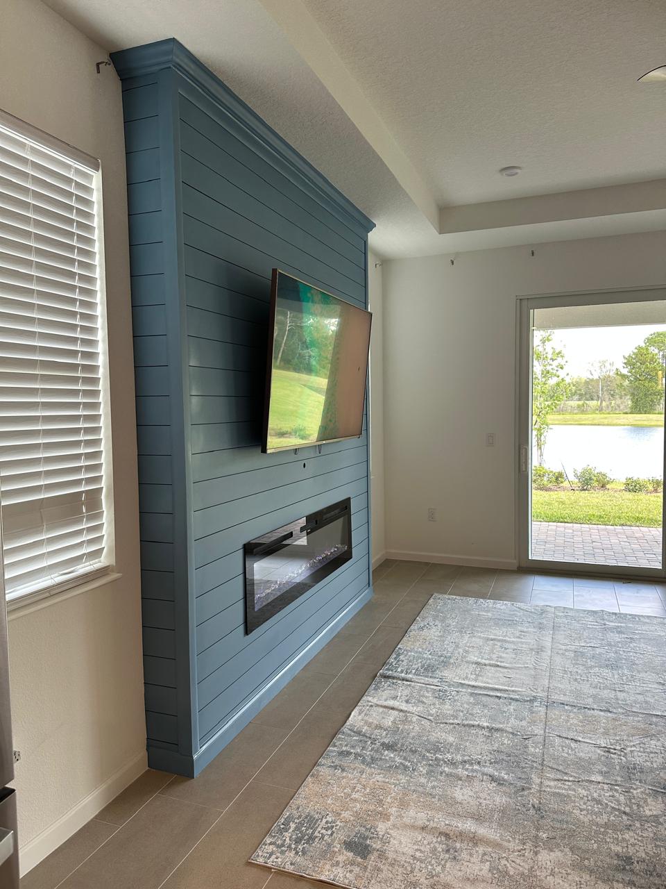 Side view of custom blue shiplap fireplace wall with mounted TV in Tavares, Florida