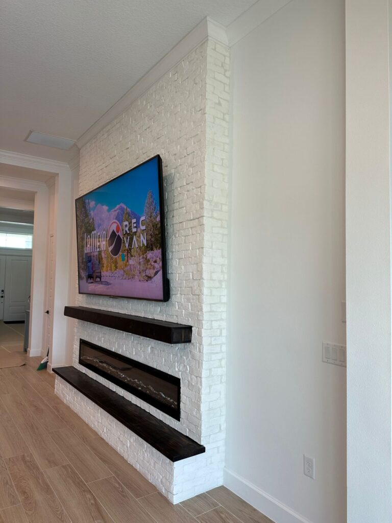 completed-white-brick-fireplace-wall-in-orlando.jpg Completed White Brick Fireplace Wall in Orlando with mounted TV, full-height brick finish and custom crown molding