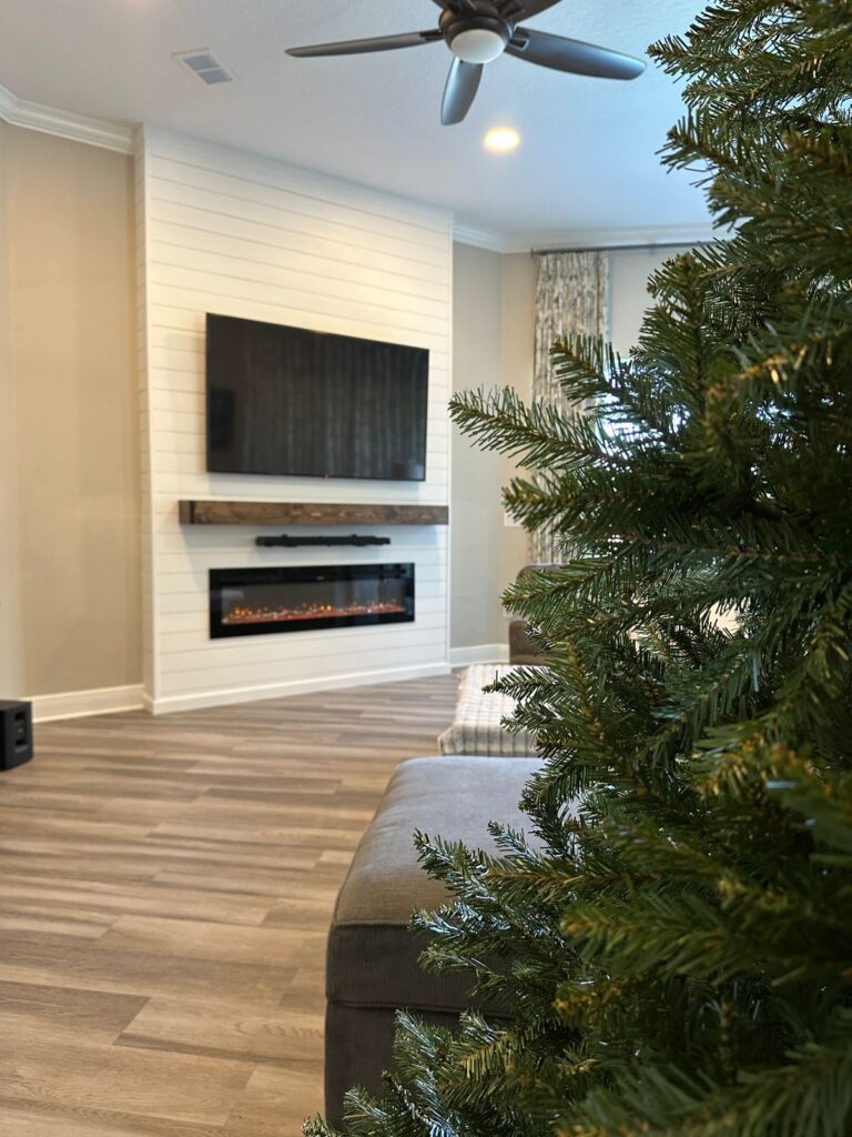white-shiplap-fireplace-wall-christmas-decor-clermont.jpg Completed white shiplap fireplace wall with floating shelves and Christmas decor in Clermont, Florida