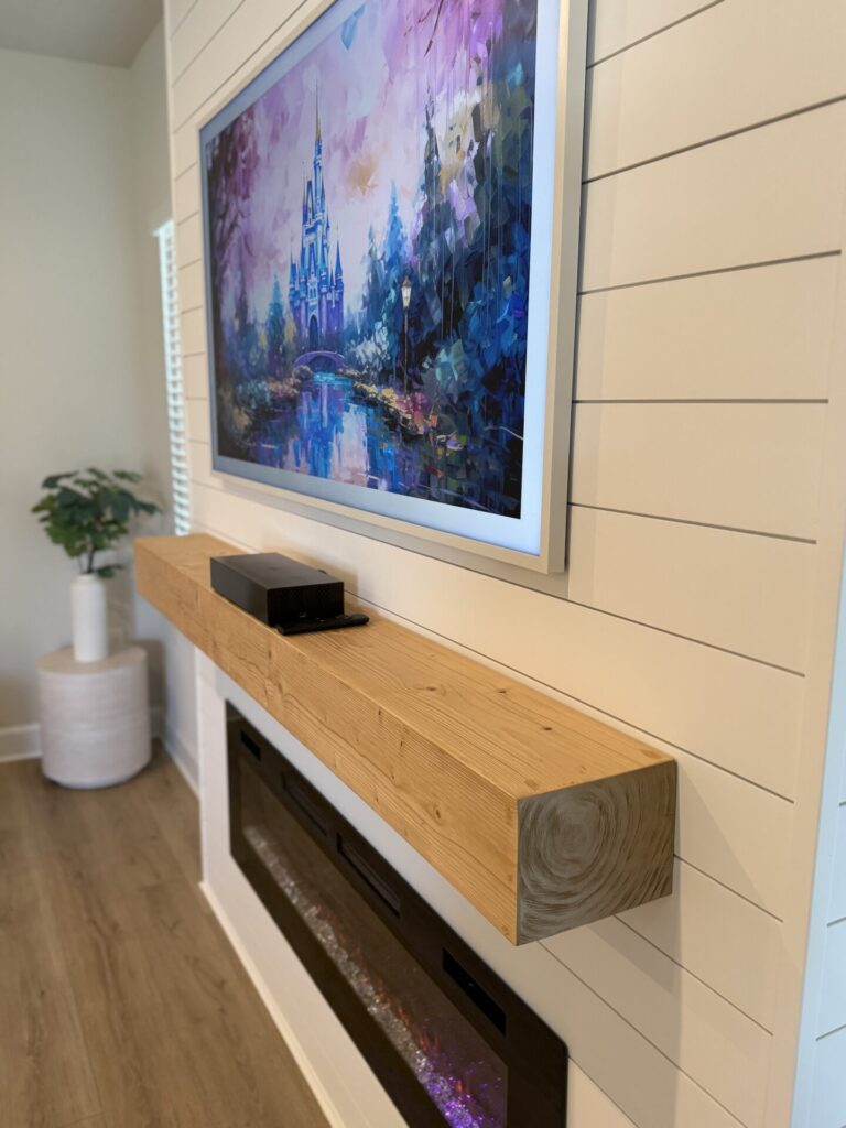 completed-white-shiplap-fireplace-wall-tv-mantel-orlando.jpg Side view of a completed white shiplap fireplace wall with mounted TV and wood mantel in Orlando
