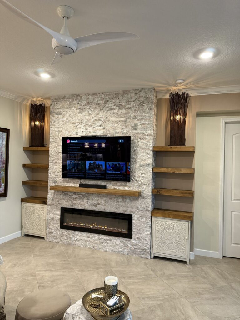 Front view of ledger stone fireplace wall with shelves and integrated lighting in Melbourne, Florida