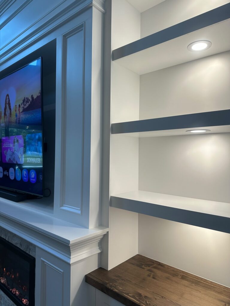 Recessed TV Niche and Illuminated Shelving Detail Recessed TV niche beside illuminated built-in display shelving