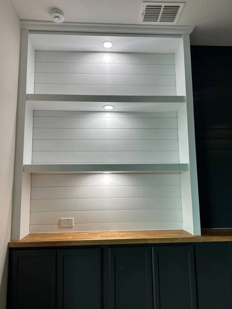 Built-In Shelves for Orlando Media Wall Built-in shelves for an Orlando media wall with cabinet storage, accent lighting, and custom trim detail