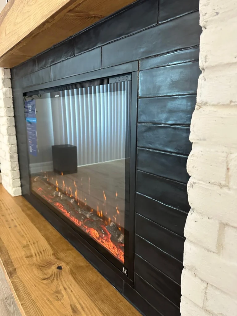 Electric Fireplace Wall Detail in Orlando Electric fireplace wall detail in Orlando with white brick surround, black fireplace insert, and wood mantel