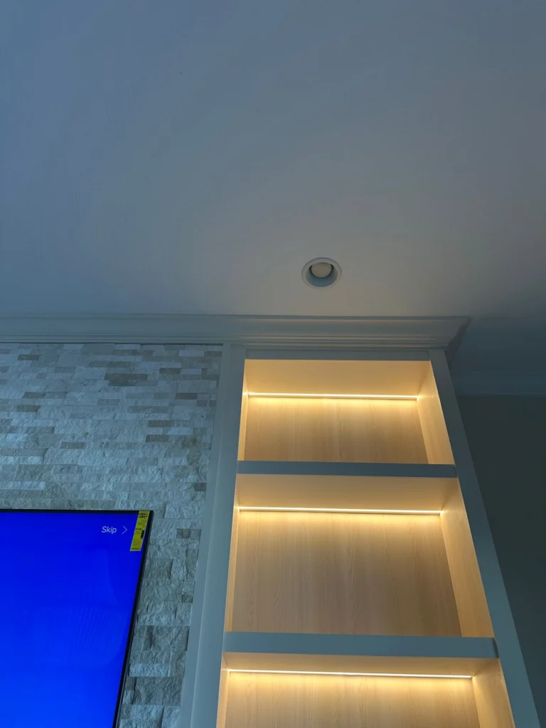 LED Shelf Lighting for Orlando Media Wall LED shelf lighting on a custom Orlando media wall with built-in shelving and stone fireplace detail