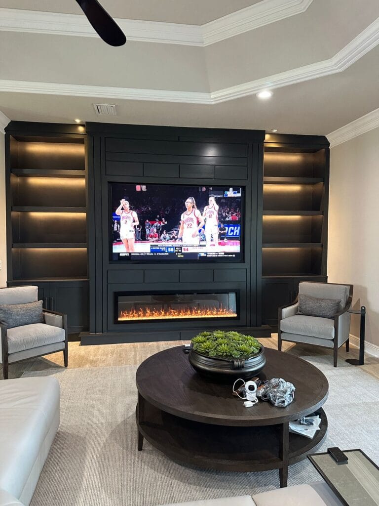 Black Media Wall with LED Accent Lighting Custom black media wall with furniture-grade cabinetry and warm accent lighting