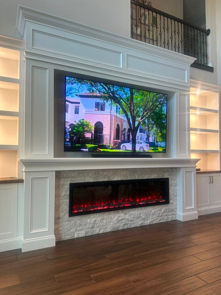 Luxury Custom Fireplace Wall Luxury custom fireplace wall featuring stone surround, built-in cabinetry, and illuminated shelving