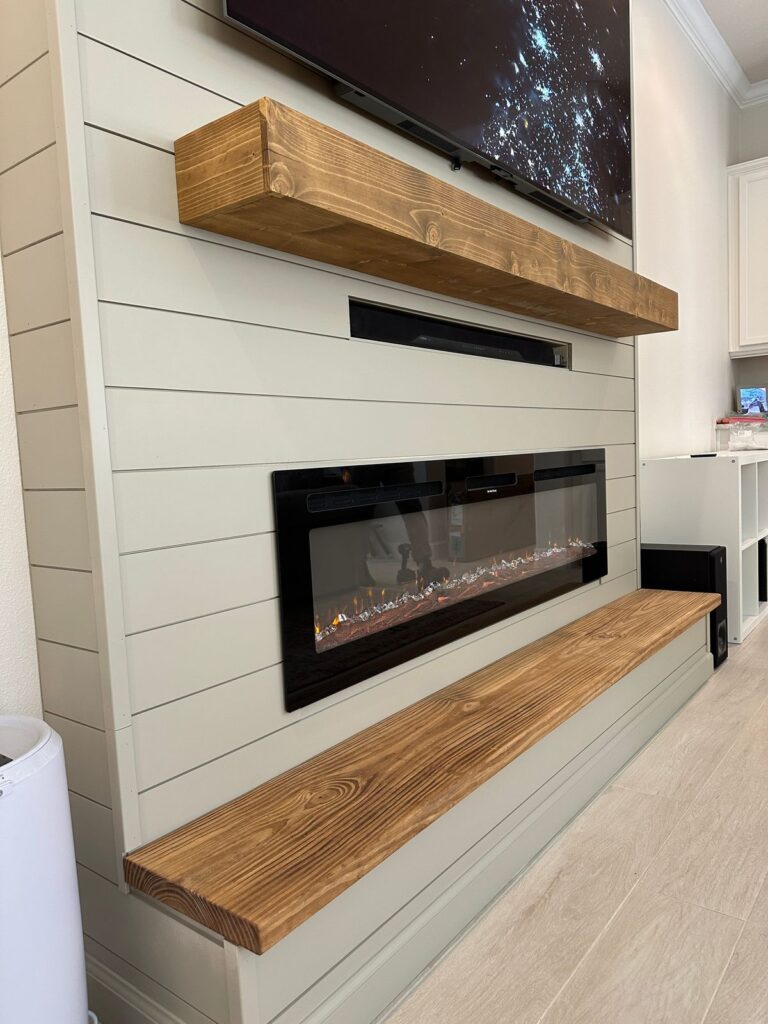 Sage shiplap fireplace wall with linear electric fireplace and handcrafted wood hearth bench in Melbourne