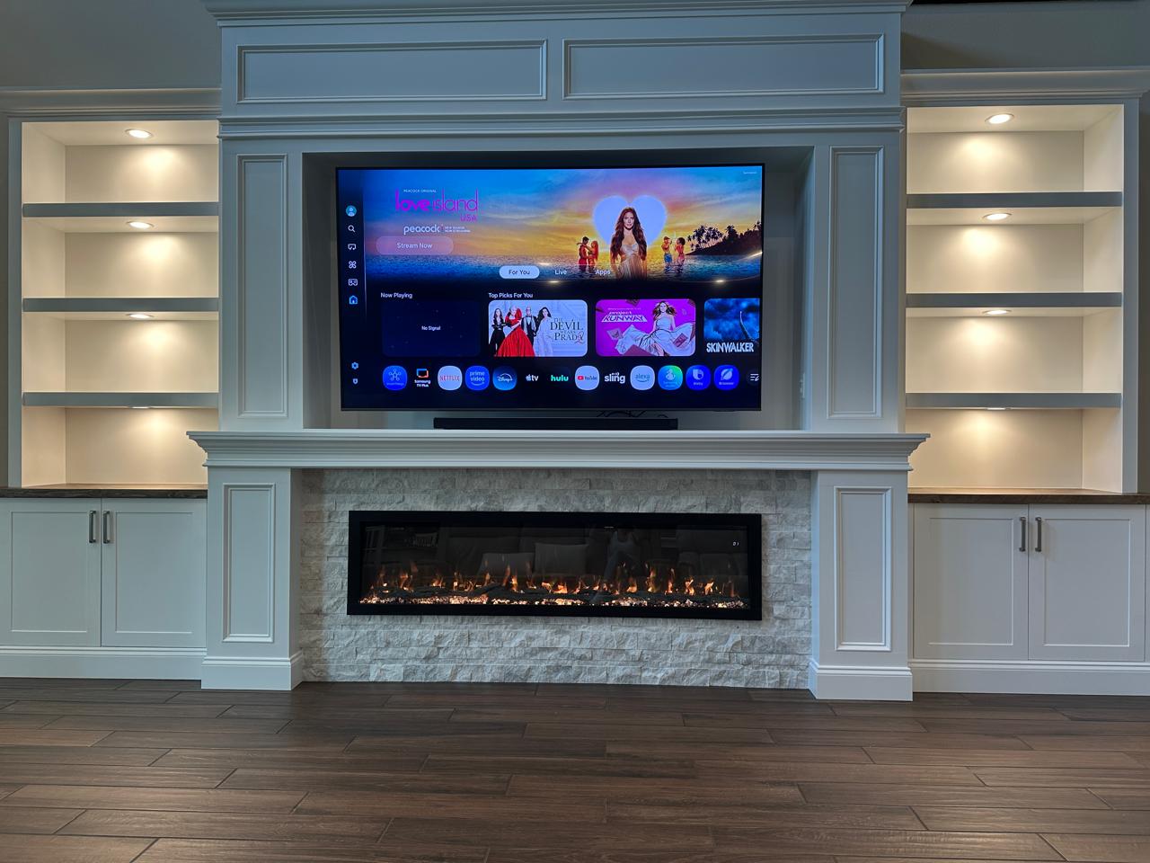 Custom TV media walls Tampa FL with built-in cabinets, illuminated shelves, and a modern entertainment wall design