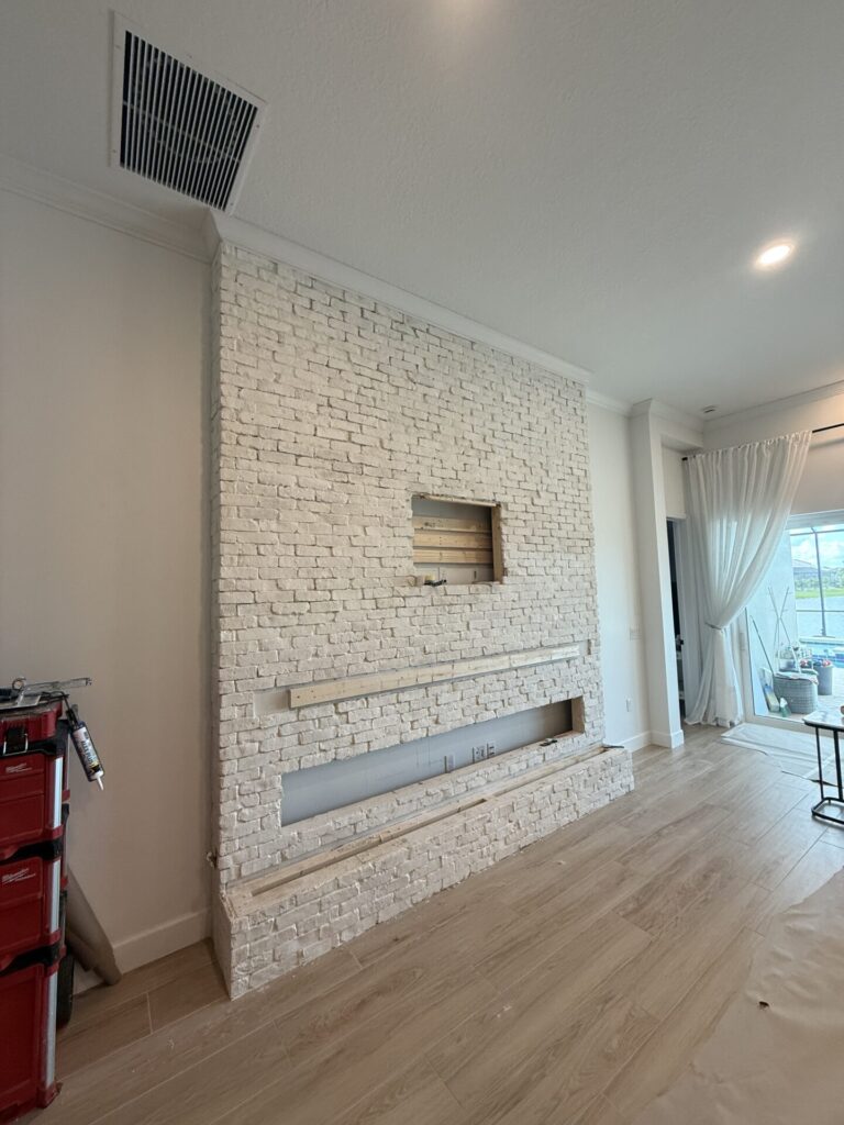 white-brick-fireplace-wall-in-orlando-construction.jpg White Brick Fireplace Wall in Orlando during construction with Old Chicago brick and openings prepared for the TV and linear fireplace