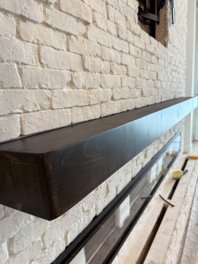 white-brick-fireplace-wall-in-orlando-wood-mantel.jpg White Brick Fireplace Wall in Orlando with a handcrafted dark wood mantel installed over Old Chicago white brick