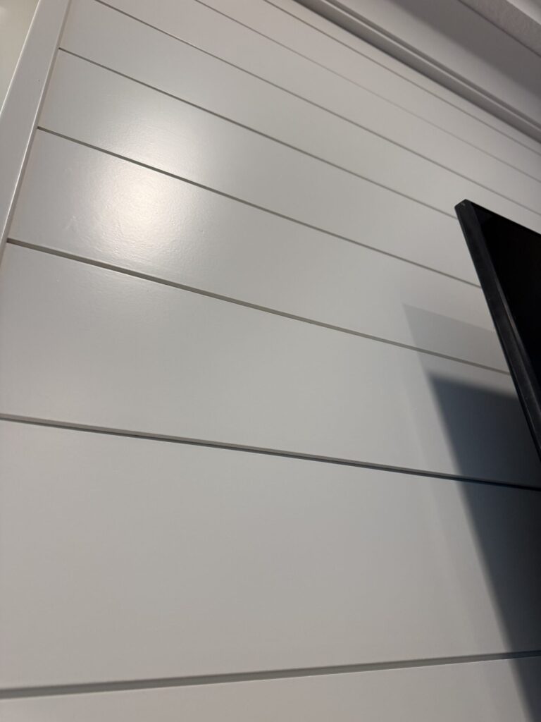 Horizontal white shiplap detail behind the TV on a custom Orlando fireplace media wall