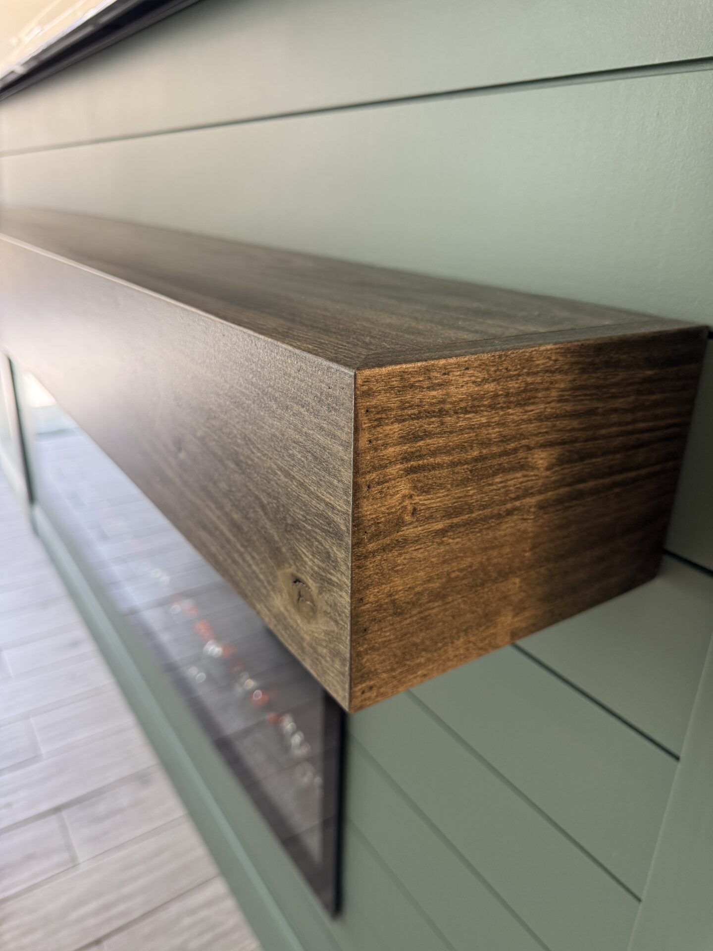 Wood Mantel Detail – Windermere TV Media Wall Close-up of the stained wood mantel on a custom sage green TV media wall in Windermere