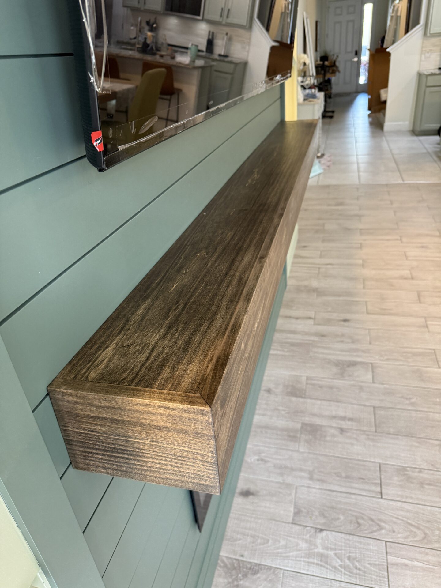Custom Wood Mantel – Windermere Luxury TV Media Wall Custom stained wood mantel detail for a luxury TV media wall in Windermere