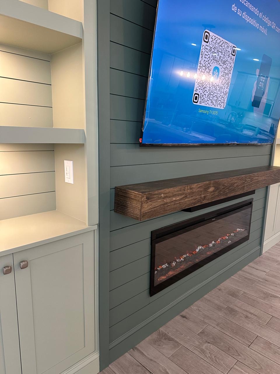 Side View – Luxury TV Media Wall in Windermere Side-angle view of a luxury TV media wall in Windermere with sage green shiplap, wood mantel and electric fireplace