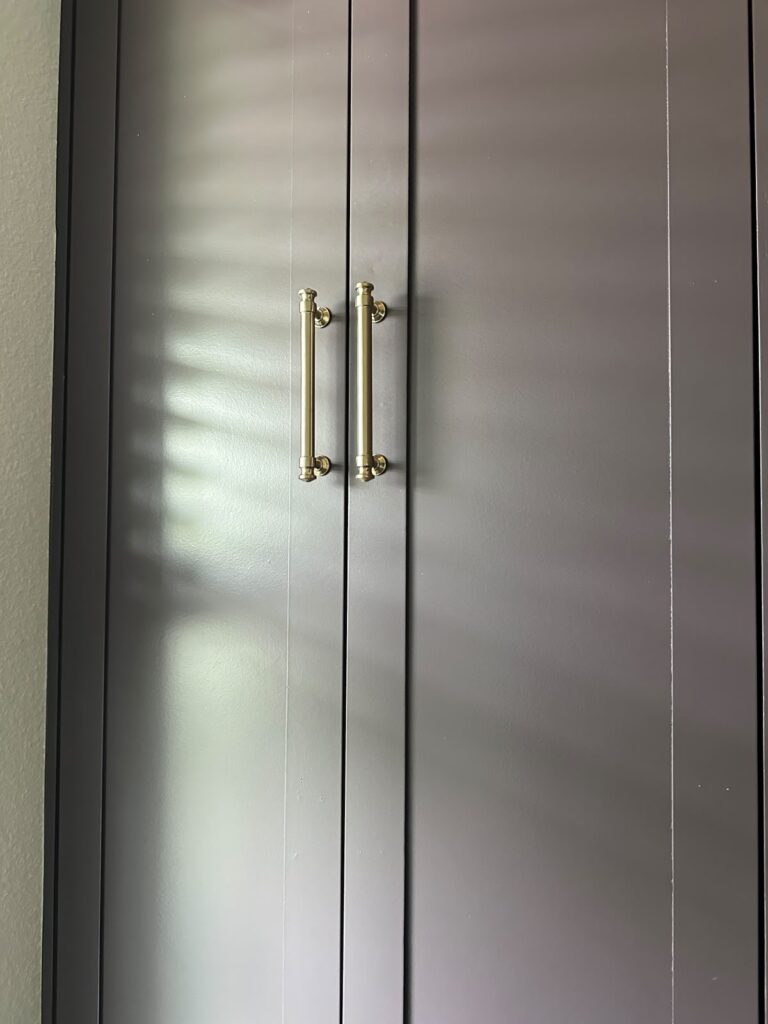 Custom cabinet doors with brass hardware in a luxury built-in home office in Orlando
