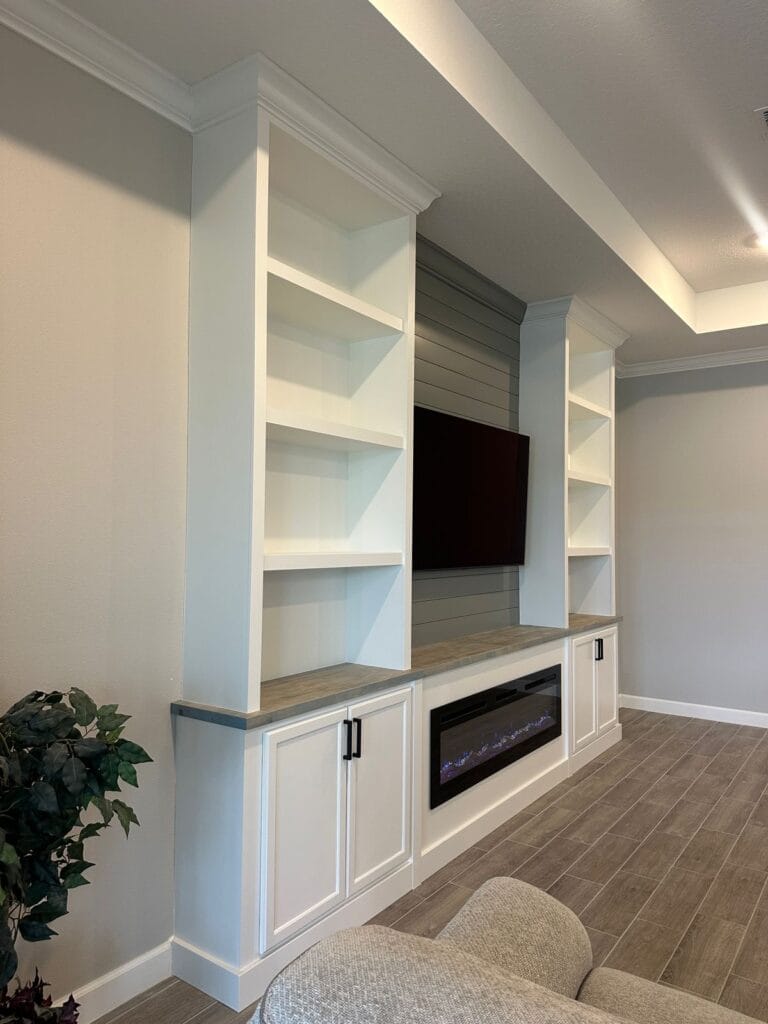 Custom Media Wall in Palm Bay — Left-Side View Custom media wall in Palm Bay viewed from the left, with white cabinets, open shelves and a gray shiplap center.