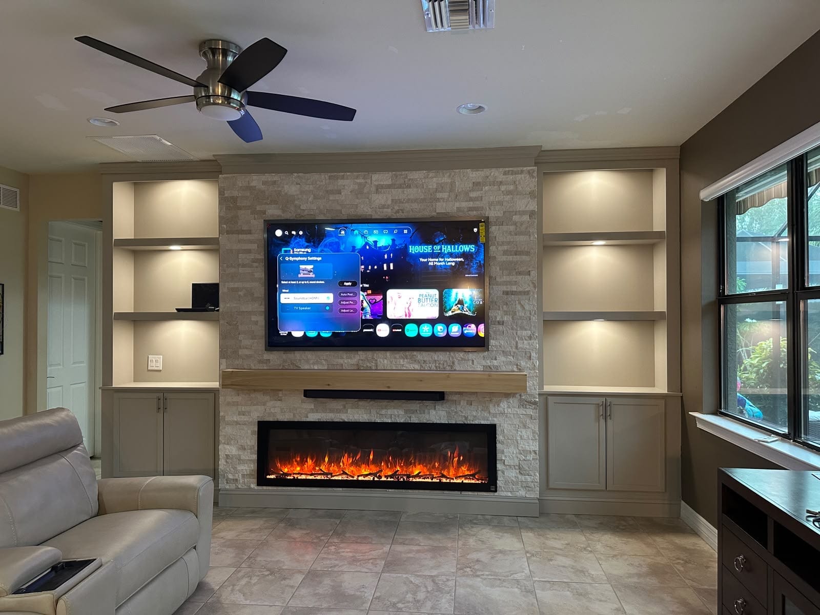 Finished light ledger stone media wall with linear fireplace in Ave Maria Florida