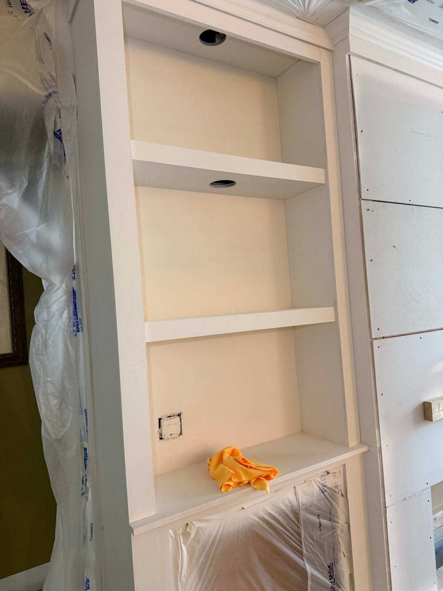 Primed custom shelves and protected cabinetry during finishing