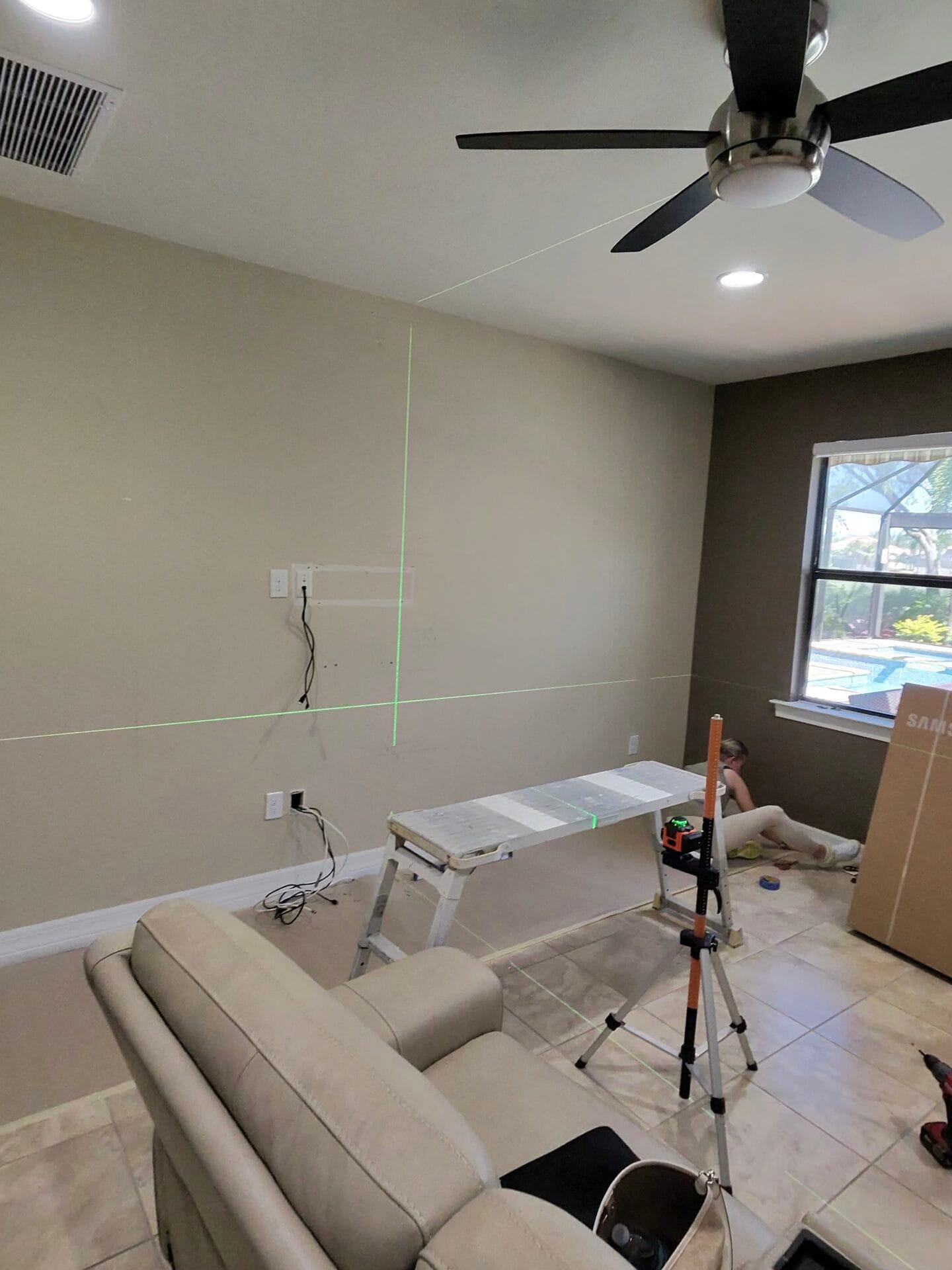 Laser layout marking the custom media wall position in Ave Maria Florida